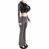 A mannequin wearing a two-piece outfit consisting of a black cropped long-sleeve top with a large black faux-fur collar and gray acid-wash flare pants with metal studs at the waist, set against a plain white background.
